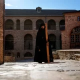 A monk using a mallet and plank to summon monks and visitors to the afternoon prayers, pauses at the Pantokrator Monastery in the Mount Athos, northern Greece. (October 13, 2022)