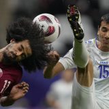 Qatar's Akram Afif, left, and Uzbekistan's Eshmurodov Umarbek fight for the ball during the quarterfinal soccer match between Qatar and Uzbekistan at Al Bayt stadium in Al Khor, Qatar. (February 3, 2024)