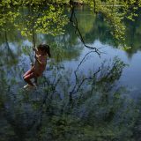 Agni a seven-year old girl uses a swing hanged from a tree, during her Easter vacation with her family at Lake Viros, also known as Springs of Louros river, near the village of Vouliasta, Epirus region, northwestern Greece. (April 25, 2022)